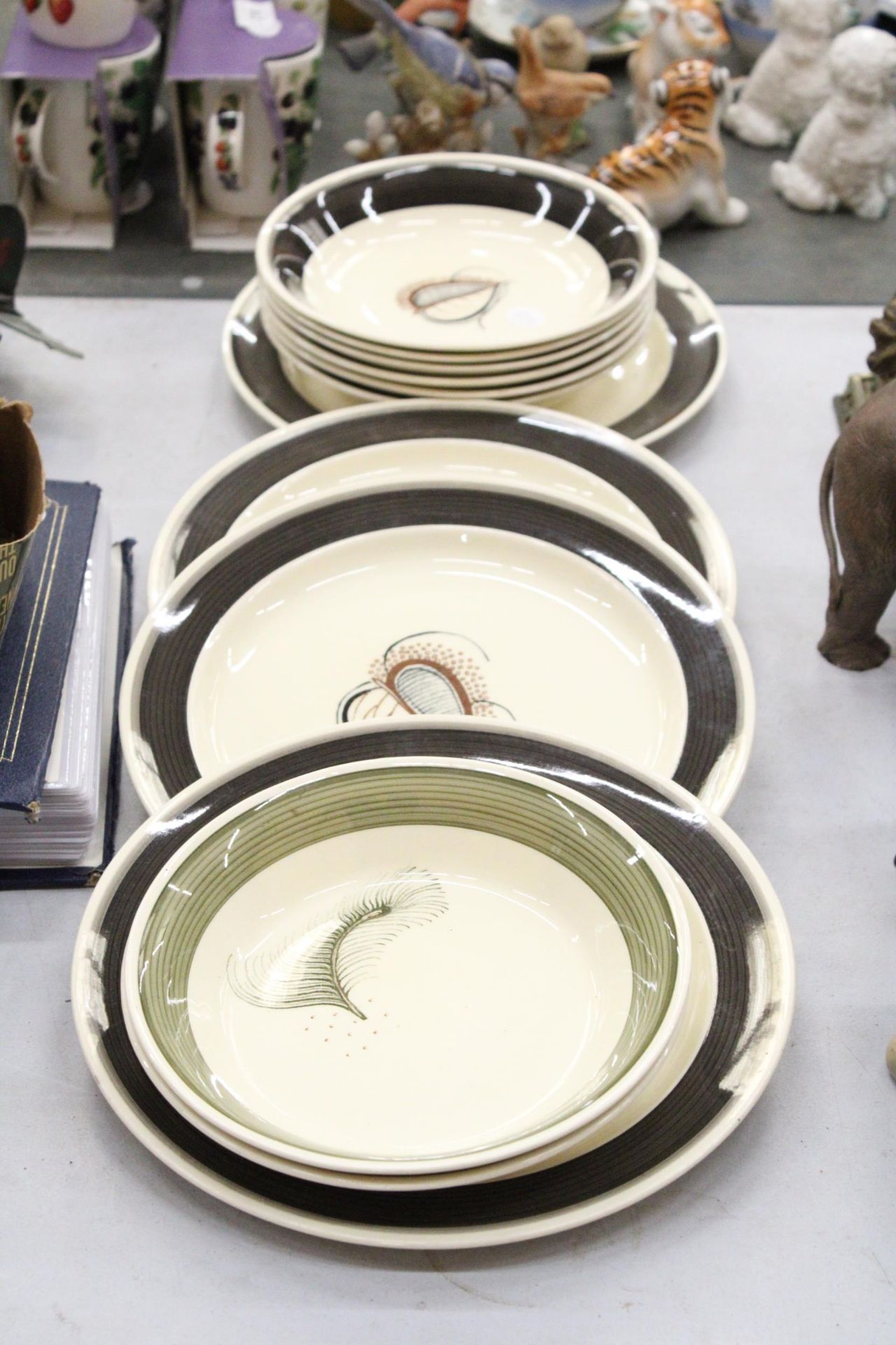 A COLLECTION OF SUSIE COOPER PLATES AND BOWLS TO INCLUDE ( GREEN FEATHER ) AND ( CHARCOAL SKELETON