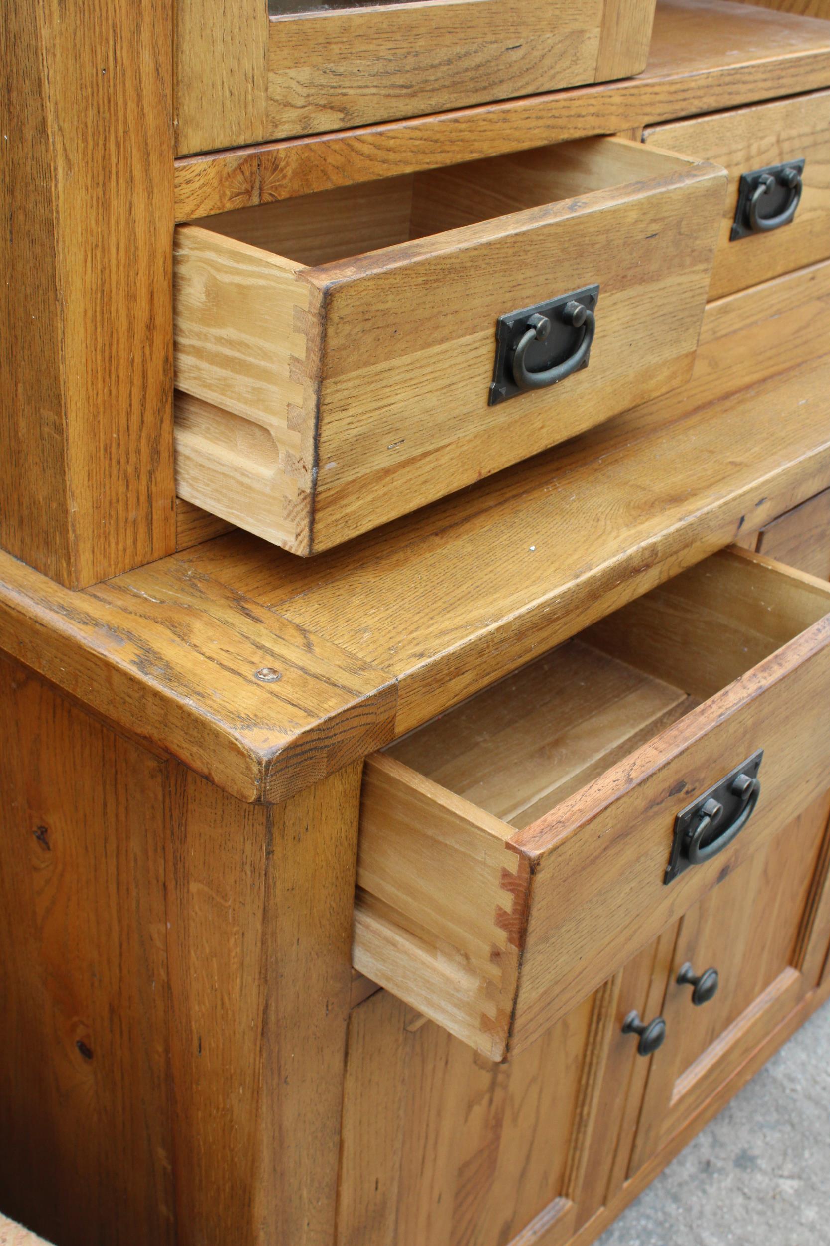 A OAK TWO DOOR BOOKCASE ON BASE, ENCLOSING SIX DRAWERS AND THREE CUPBOARDS, 55" WIDE - Image 4 of 6