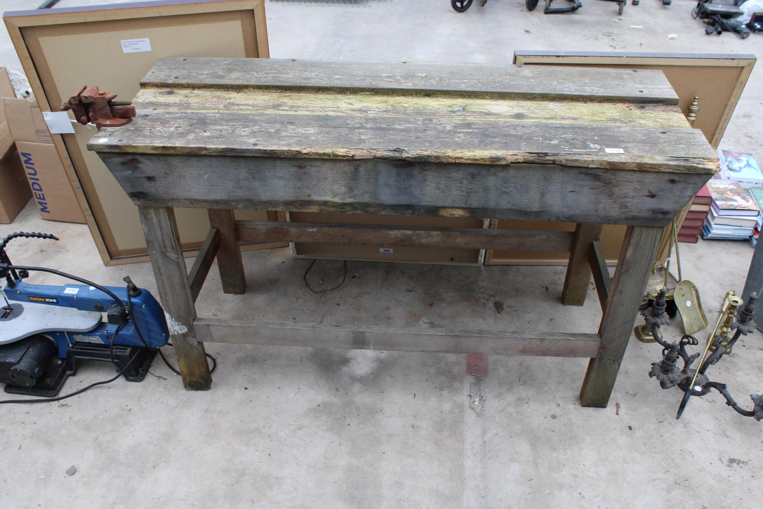 A VINTAGE WOODEN WORK BENCH WITH SMALL BENCH VICE