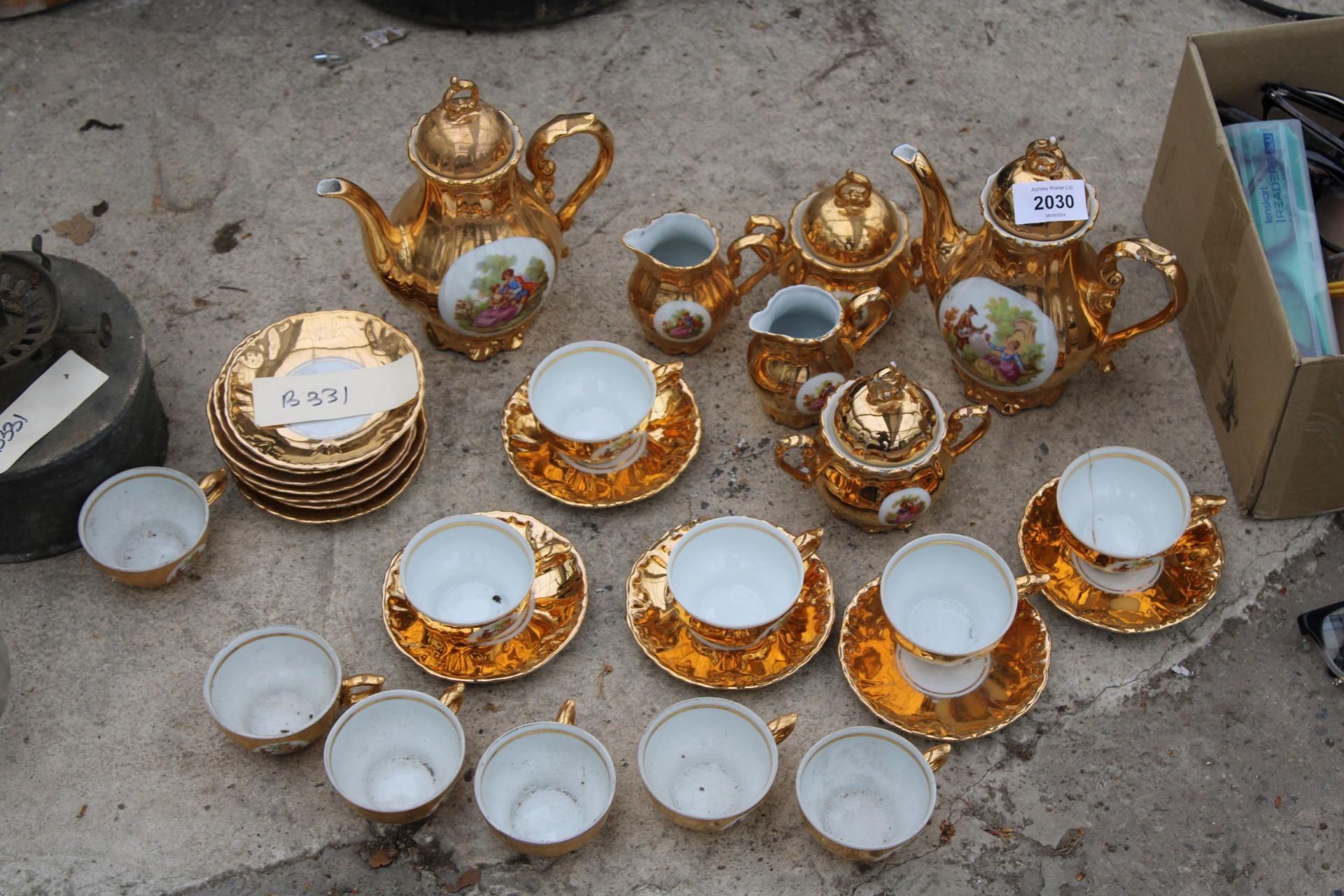 AN ASSORTMENT OF GILT CERAMIC TEA SERVICE ITEMS TO INCLUDE CUPS AND SAUCERS AND TEAPOTS ETC