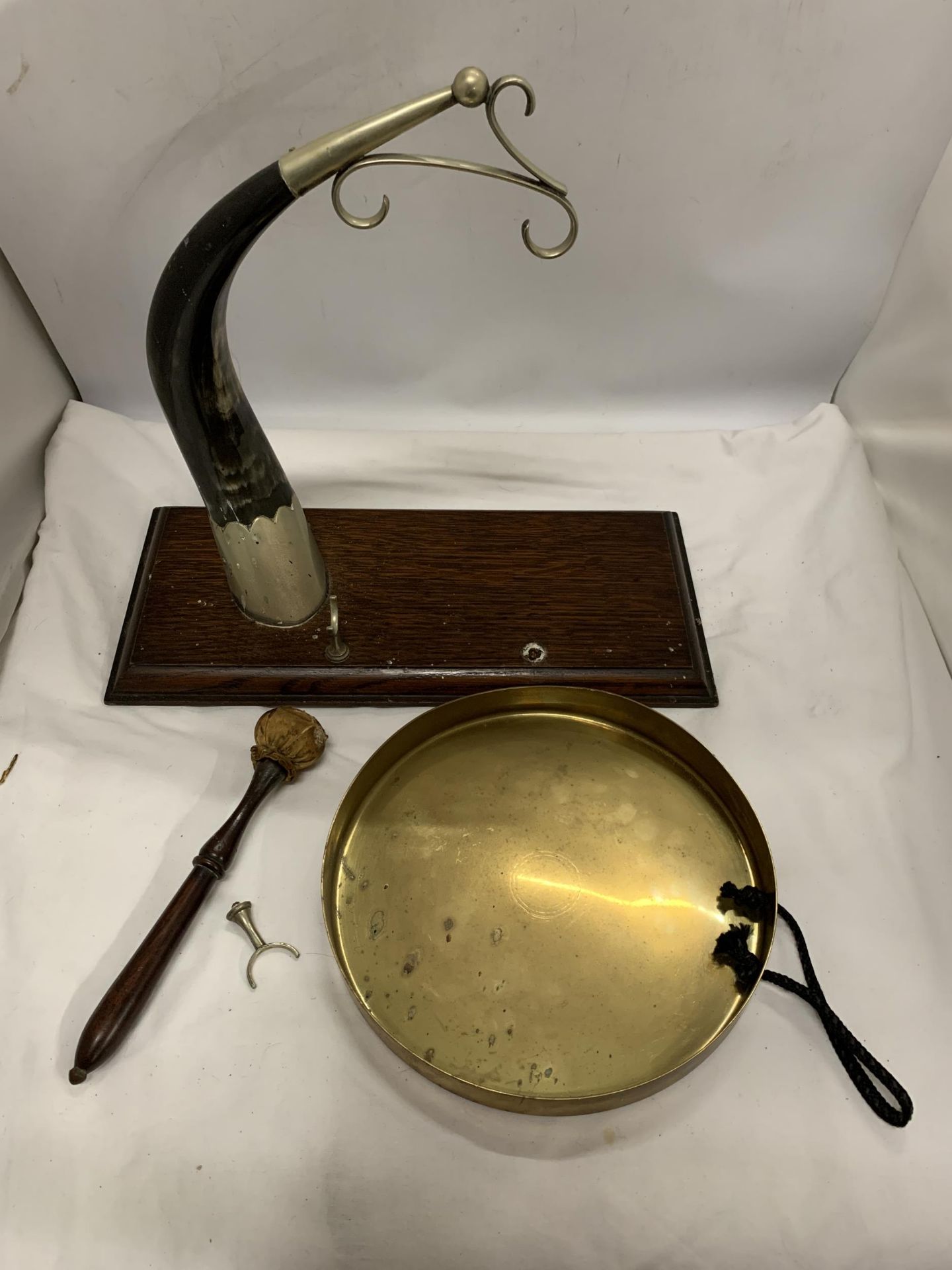 A VINTAGE BRASS AND HORN HANGING STAND ON WOODEN PLINTH TOGETHER WITH A BRASS GONG