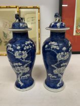 A PAIR OF CHINESE PORCELAIN BLUE AND WHITE PRUNUS PATTERN VASES WITH LID AND FOO DOG FINIAL WITH