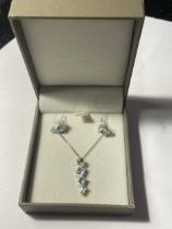 A SILVER NECKLACE AND EARRING SET WITH AQUAMARINE COLOURED STONES IN A PRESENTATION BOX