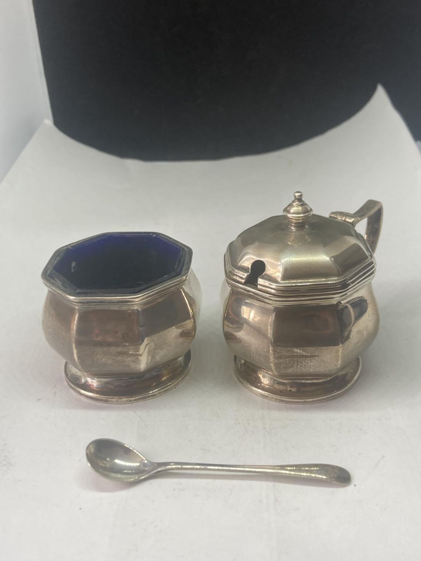 THREE HALLMARKED BIRMINGHAM SILVER ITEMS TO INCLUDE TWO CRUETS WITH BLUE GLASS LINERS AND A SPOON