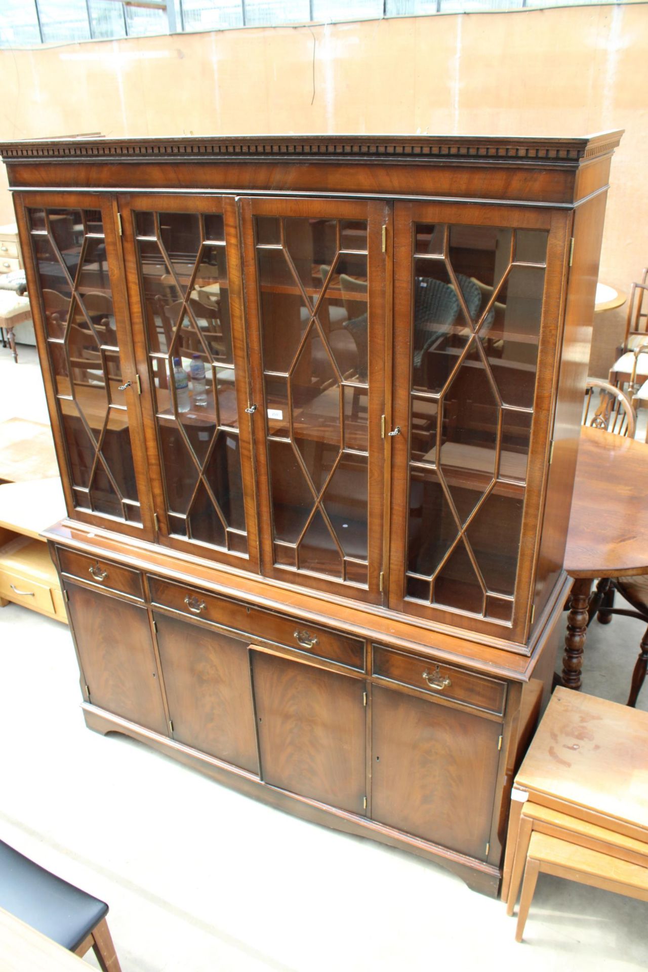 A MAHOGANY AND INLAID FOUR DOOR ASTRAGAL GLAZED BOOKCASE ON BASE ENCLOSING THREE DRAWERS AND FOUR