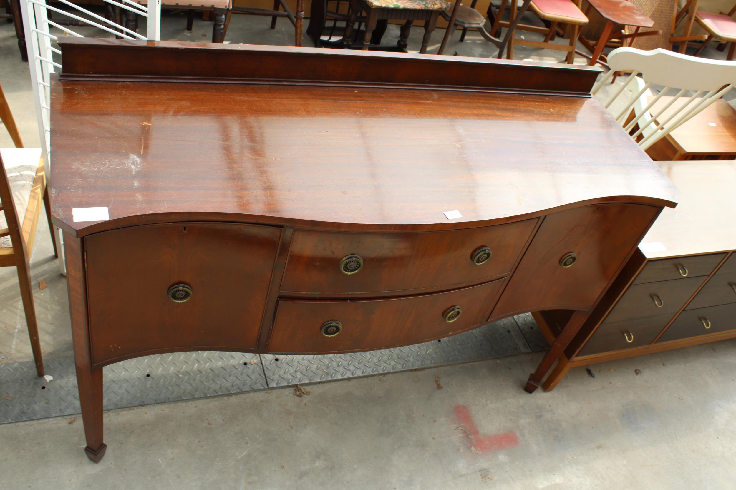 A REGENCY STYLE MAHOGANY WARING & GILLOW SERPENTINE SIDEBOARD ON TAPERING LEGS WITH SPADE FEET,
