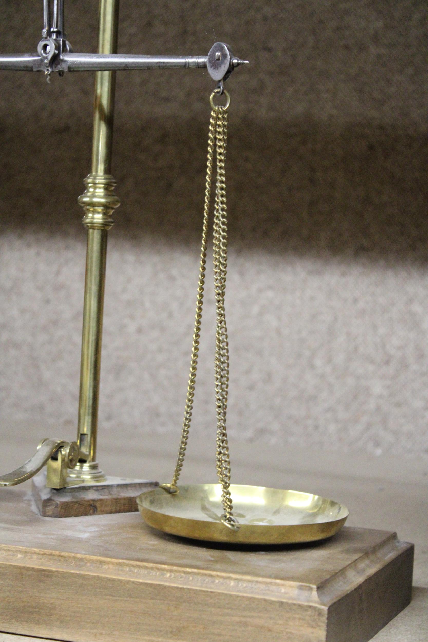 A SET OF BRASS BALANCE SCALES ON A WOODEN BASE - Image 2 of 4