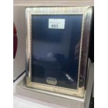 A HALLMARKED SHEFFIELD SILVER PHOTOGRAPH FRAMED TO HOLD A 5" X 7" PICTURE IN ORIGINAL PRESENTATION