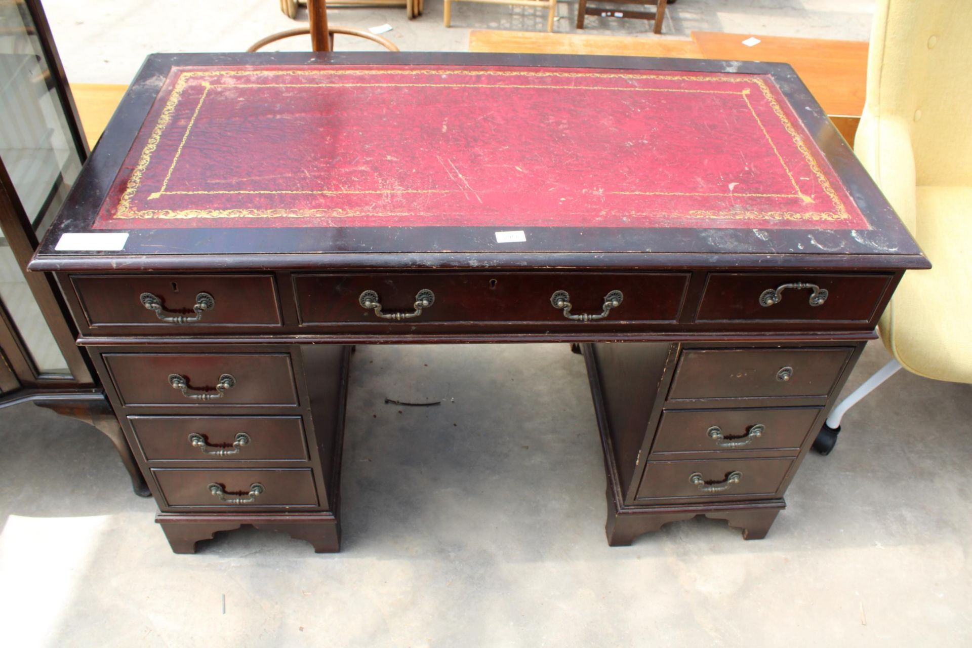 A MAHOGANY TWIN-PEDESTAL DESK ENCLOSING EIGHT DRAWERS AND INSET LEATHER TOP, 48" X 24"