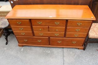 A YOUNGER CHEST ENCLOSING NINE VARIOUS SIZED DRAWERS, 57" WIDE