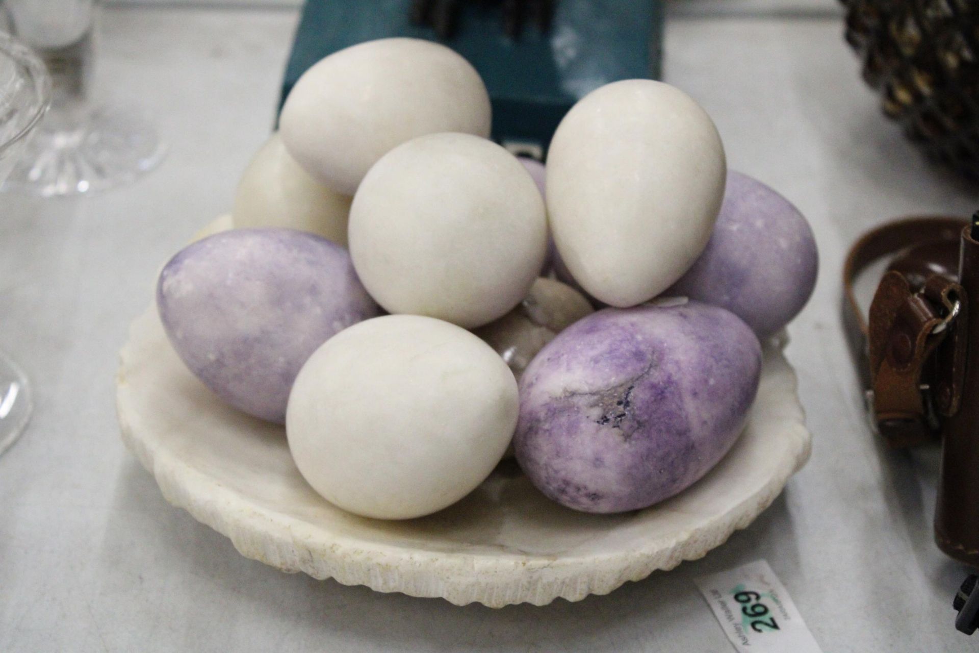 A COLLECTION OF ALABASTER EGGS IN AN ALABASTER BOWL