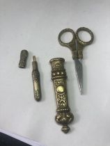 A PAIR OF DECORATIVE BRASS DRESS MAKING SCISSORS AND A NEEDLE CASE