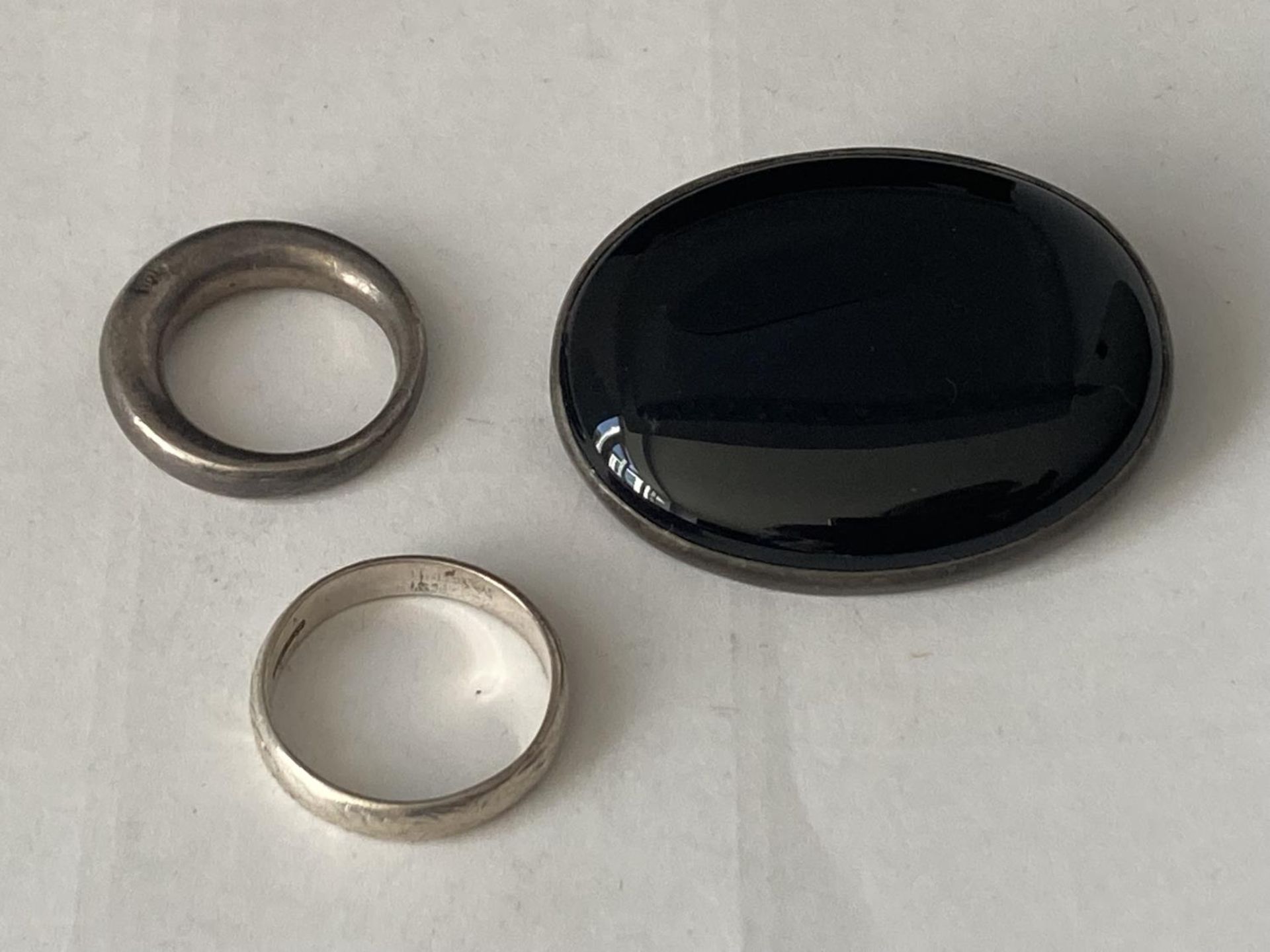 THREE SILVER ITEMS TO INCLUDE TWO RINGS AND A VINTAGE BLACK STONE BROOCH