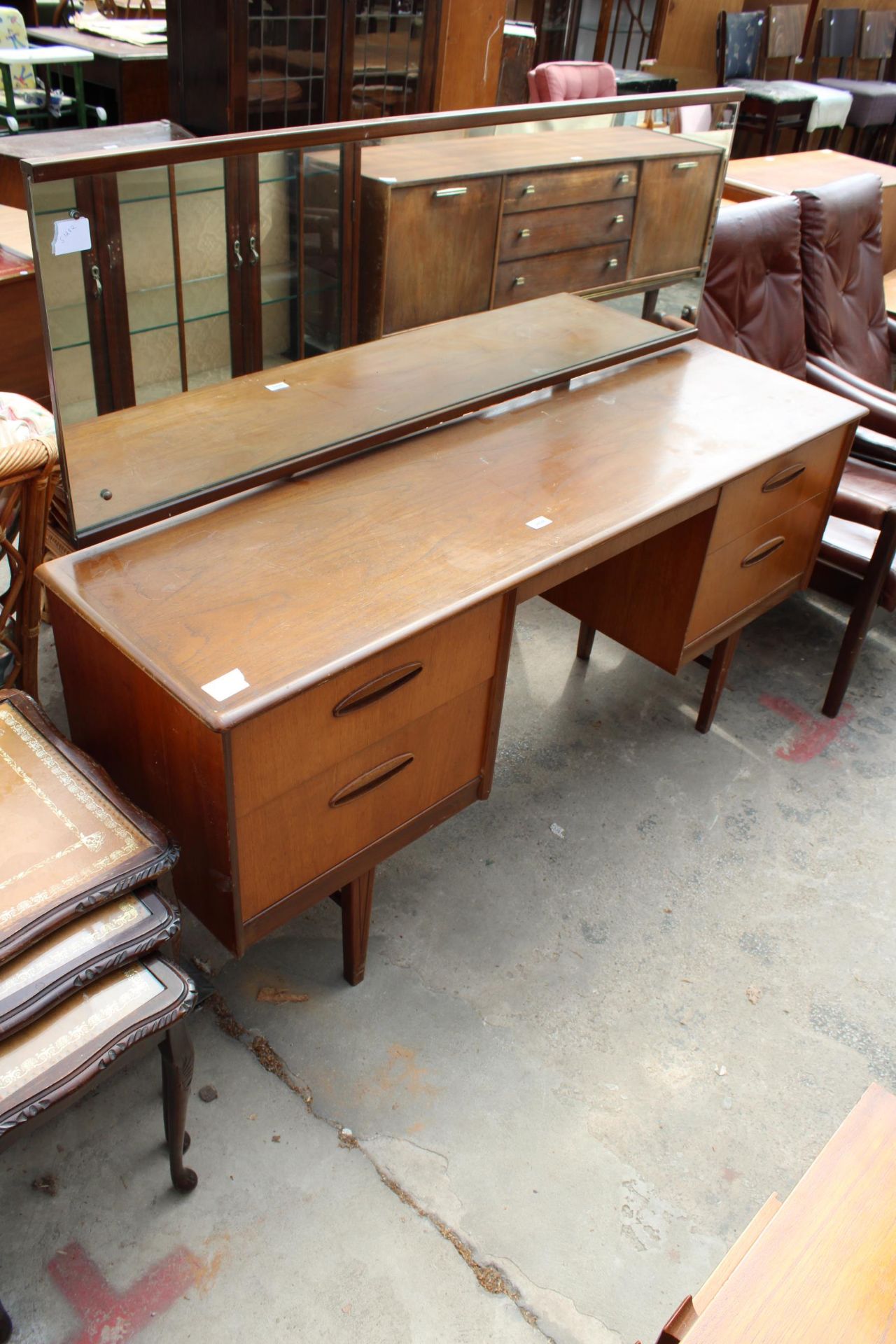 A RETRO TEAK KNEE-HOLE DRESSING TABLE ENCLOSING FOUR DRAWERS, 60" WIDE