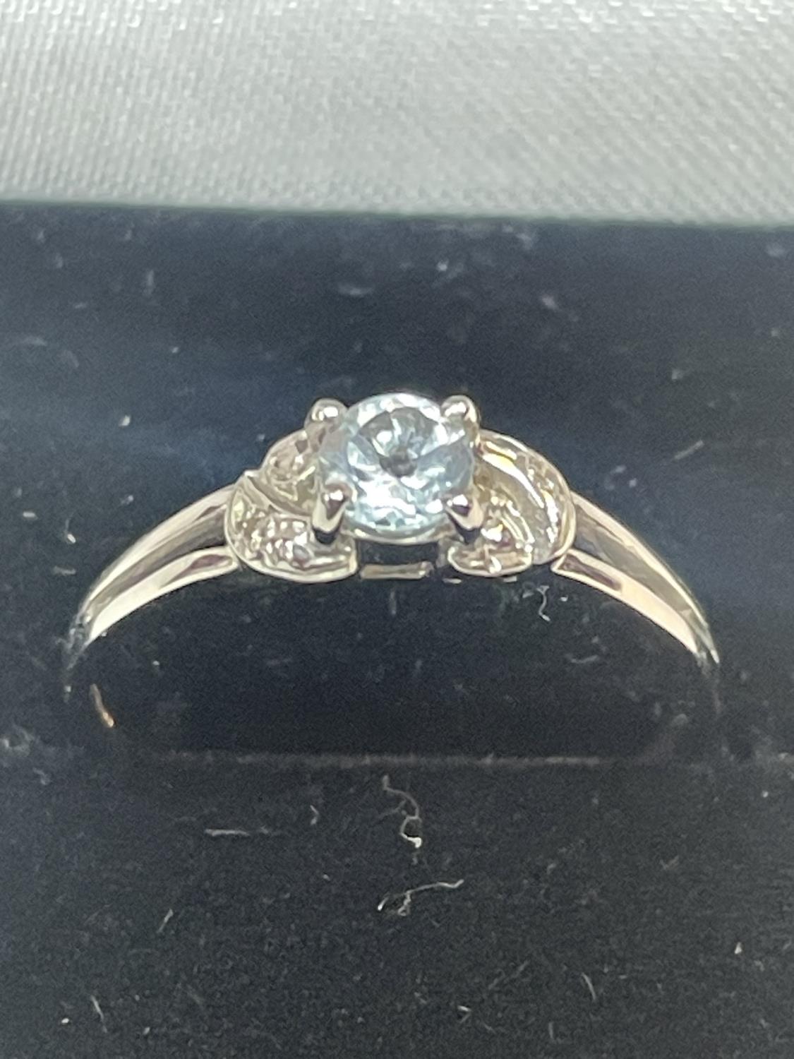 A 9 CARAT WHITE GOLD RING WITH CENTRE BLUE TOPAZ SHOULDERED BY DIAMONDS SIZE N IN A PRESENTATION BOX - Image 2 of 5