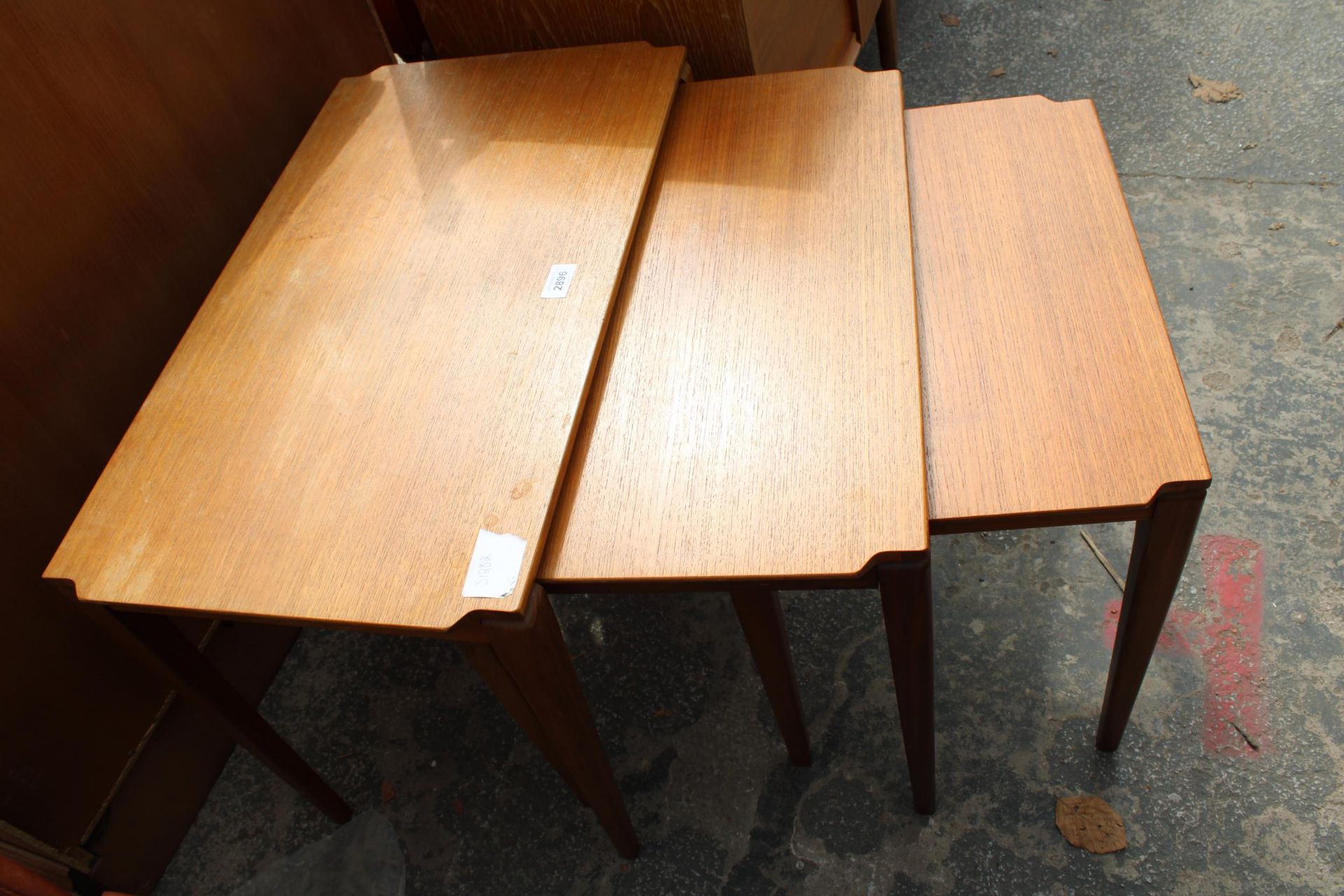 A RETRO TEAK NEST OF THREE TABLES ON TAPERING LEGS - Image 2 of 3