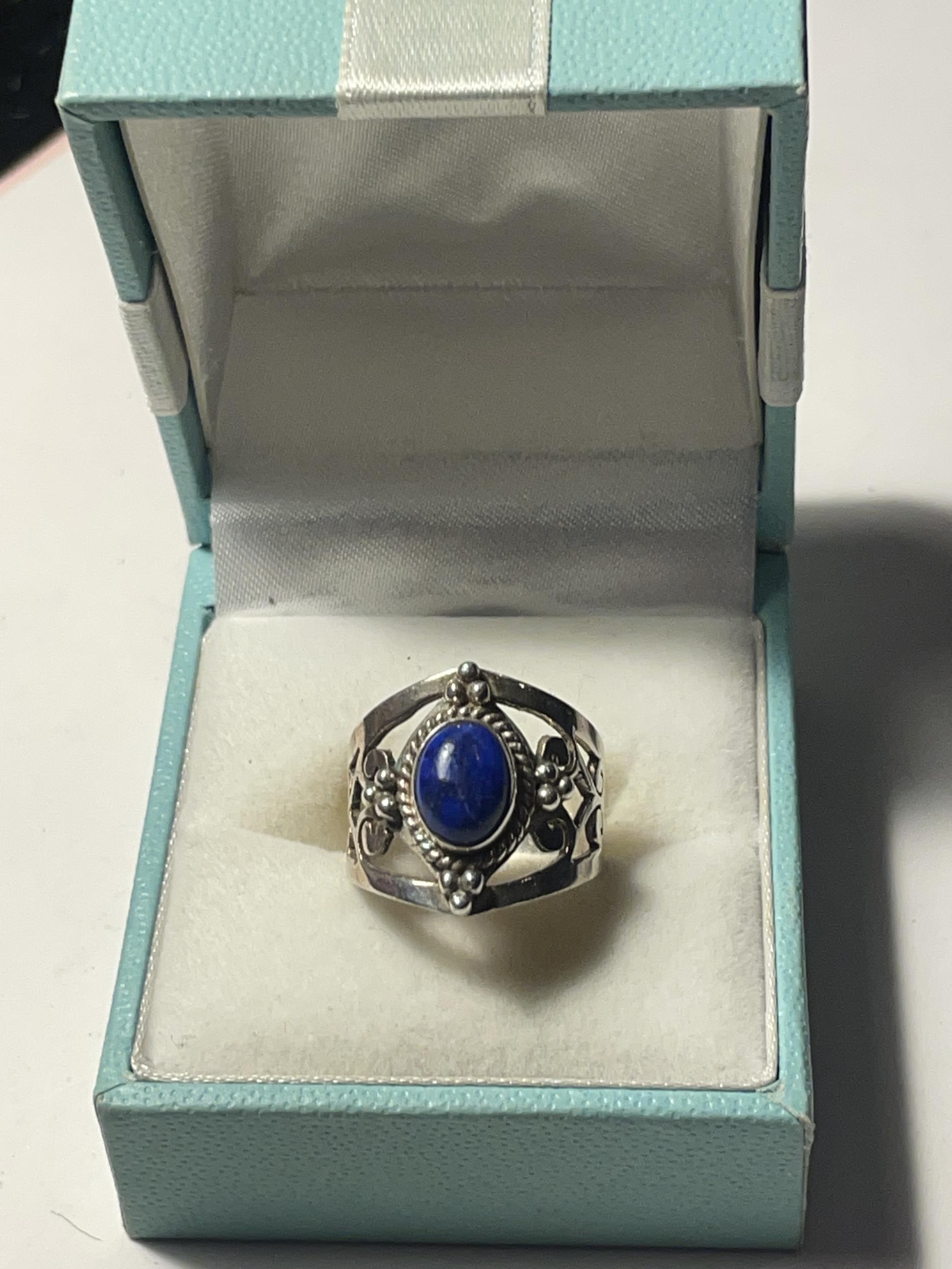 A SILVER DRESS RING WITH A BLUE CENTRE STONE IN A PRESENTATION BOX