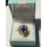 A SILVER DRESS RING WITH A BLUE CENTRE STONE IN A PRESENTATION BOX