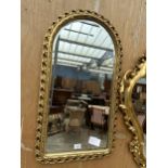 AN ARCHED GILT FRAMED MIRROR