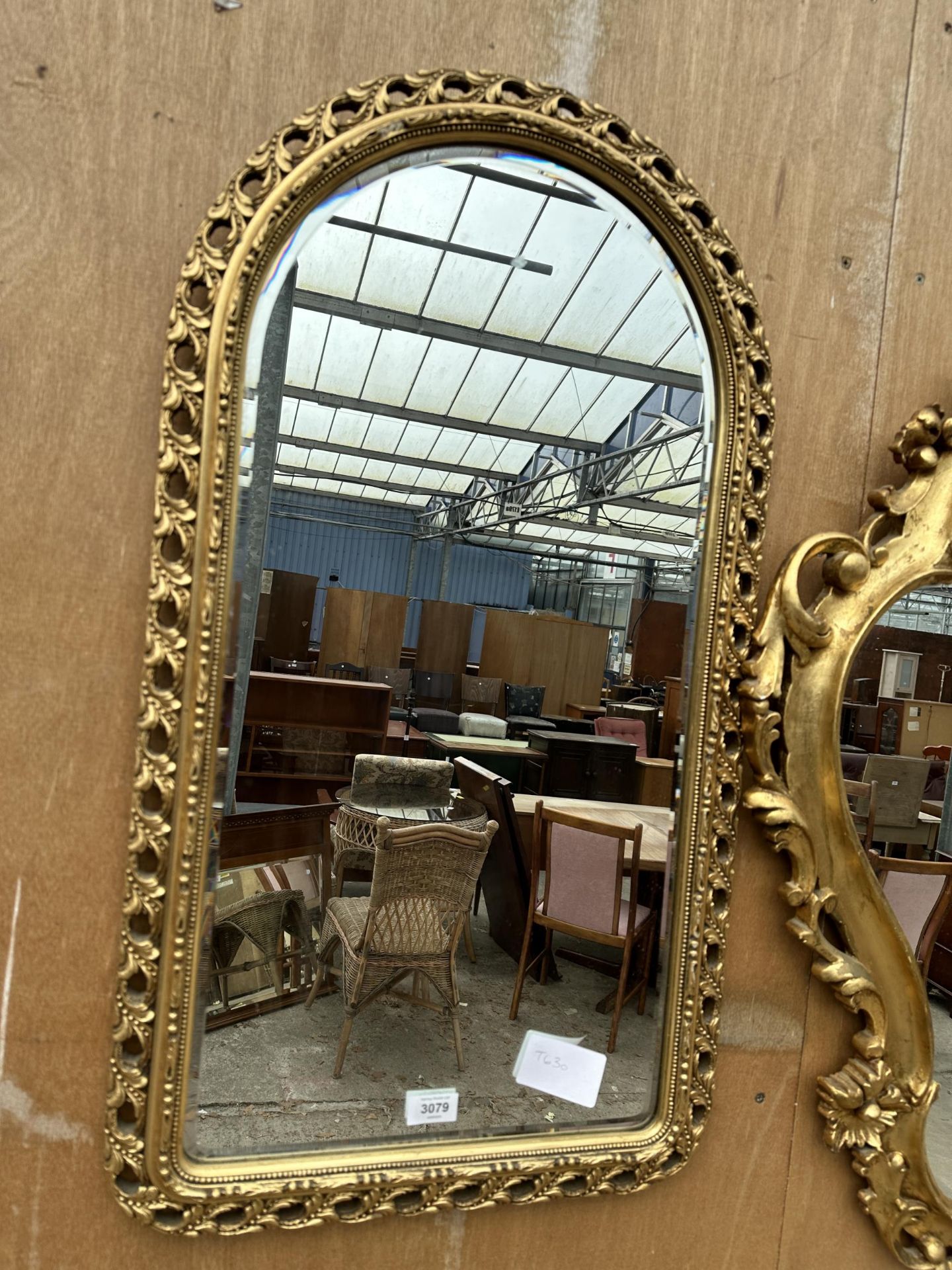 AN ARCHED GILT FRAMED MIRROR