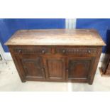 AN OAK JACOBEAN STYLE DRESSER BASE WITH CARVED PANEL DOORS AND DRAWERS, 51" WIDE