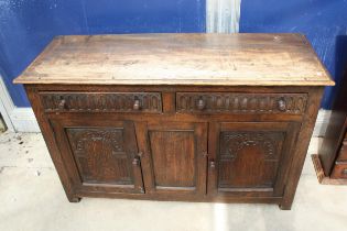 AN OAK JACOBEAN STYLE DRESSER BASE WITH CARVED PANEL DOORS AND DRAWERS, 51" WIDE