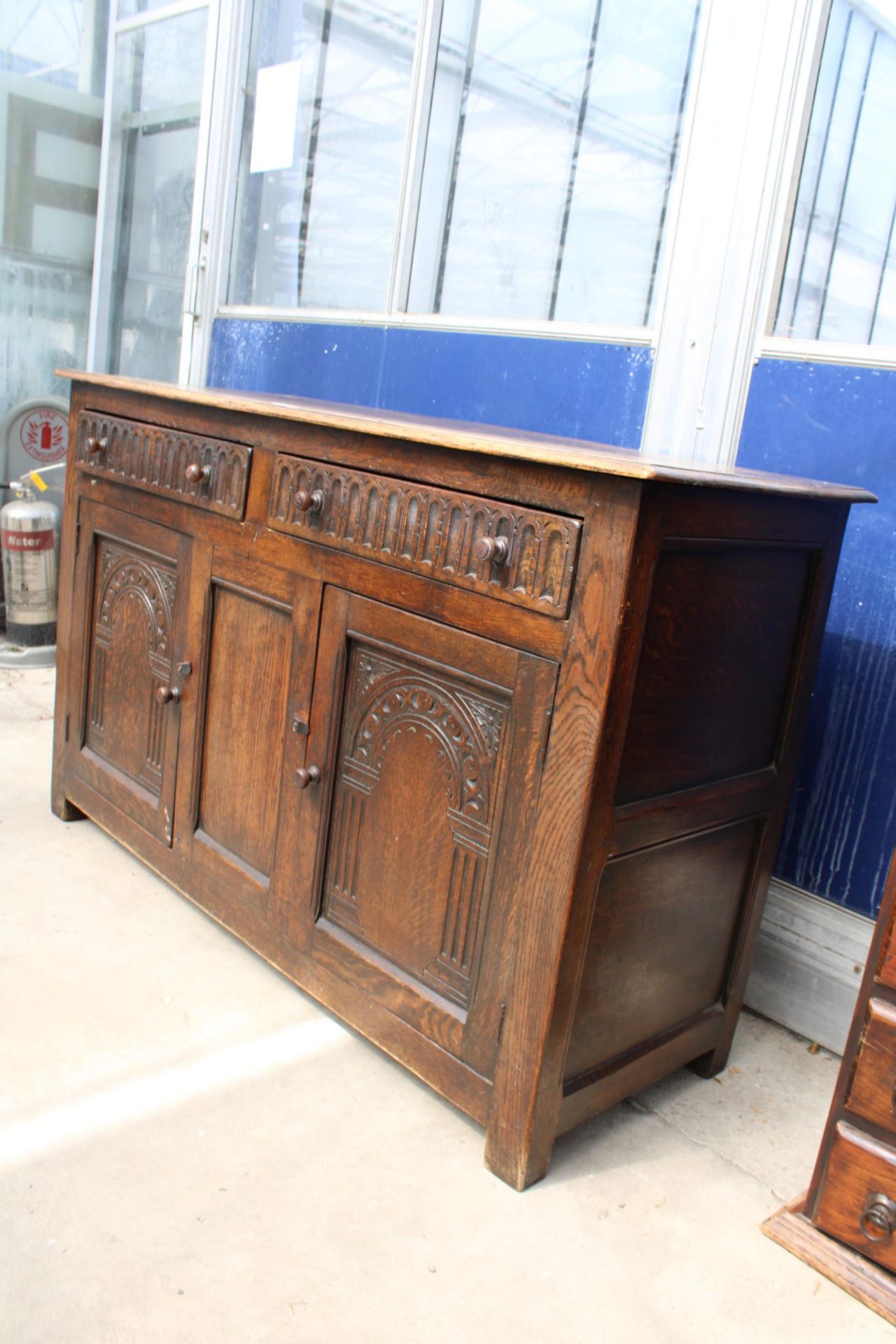 AN OAK JACOBEAN STYLE DRESSER BASE WITH CARVED PANEL DOORS AND DRAWERS, 51" WIDE - Image 2 of 3