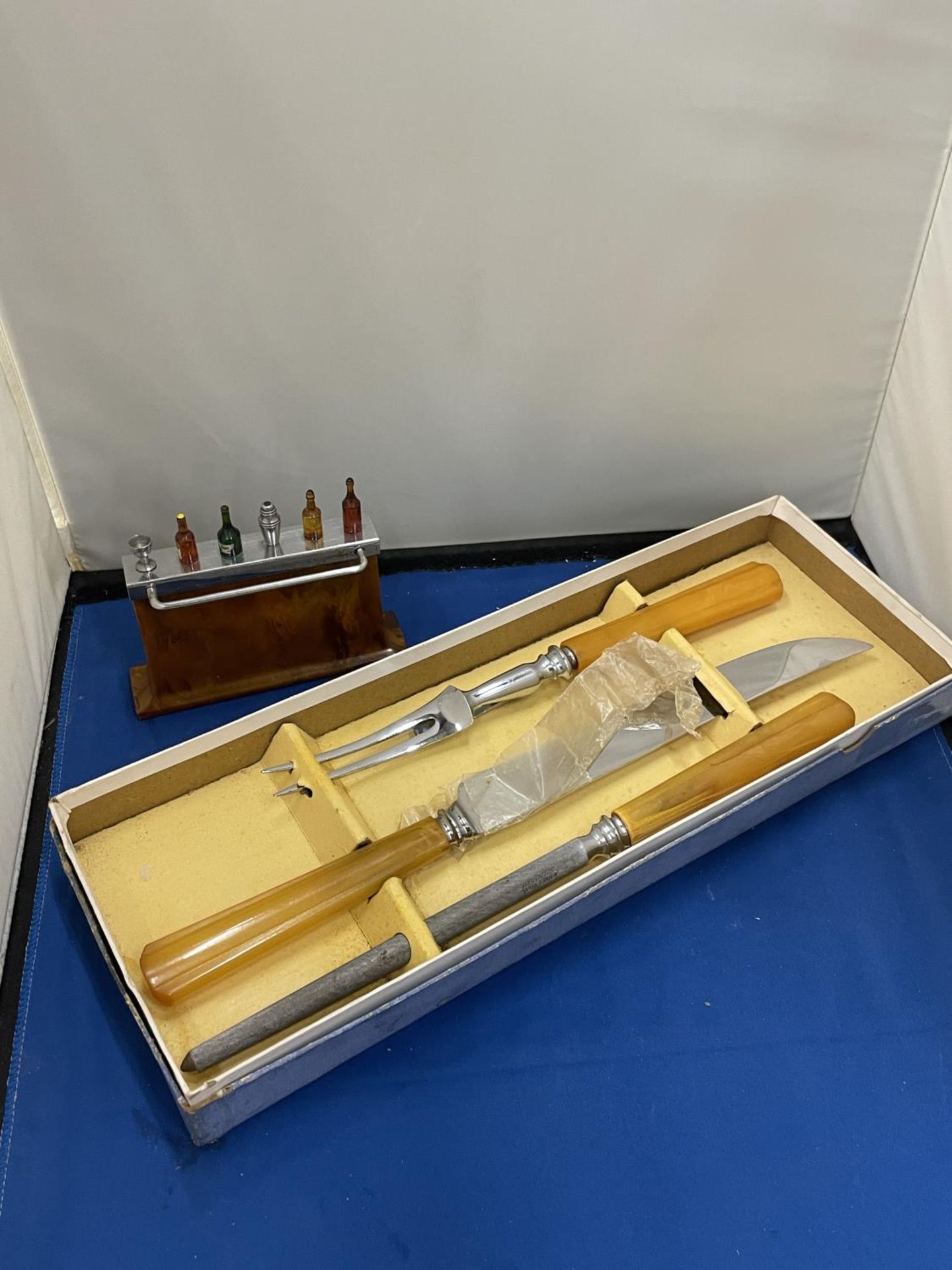 TWO VINTAGE ITEMS TO INCLUDE BOXED CARVING SET AND A BAR CONTAINING NOVELTY COCKTAIL STICKS