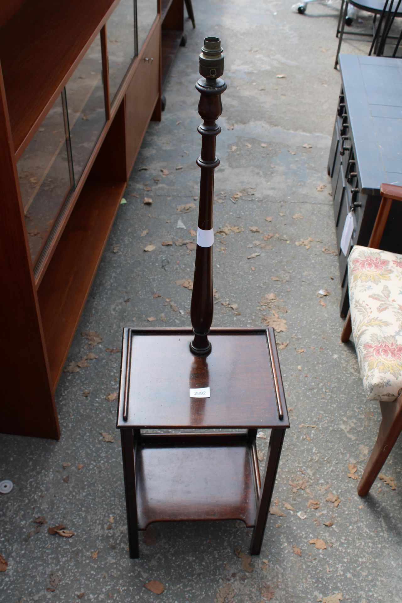 AN EARLY 20TH CENTURY MAHOGANY TWO TIER STANDARD LAMP TABLE WITH TURNED COLUMN