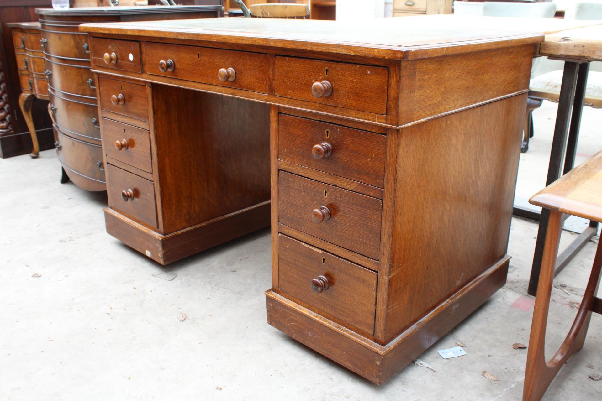 AN EDWARDIAN OAK TWIN-PEDESTAL DESK ENCLOSING NINE DRAWERS WITH INSET LEATHER TOP, 48" X 25" - Image 2 of 4