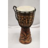 A WOODEN HAND CARVED BONGO DRUM APPROXIMATELY 40CM HIGH