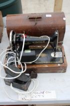 A VINTAGE ELECTRIC SINGER SEWING MACHINE WITH CARRY CASE