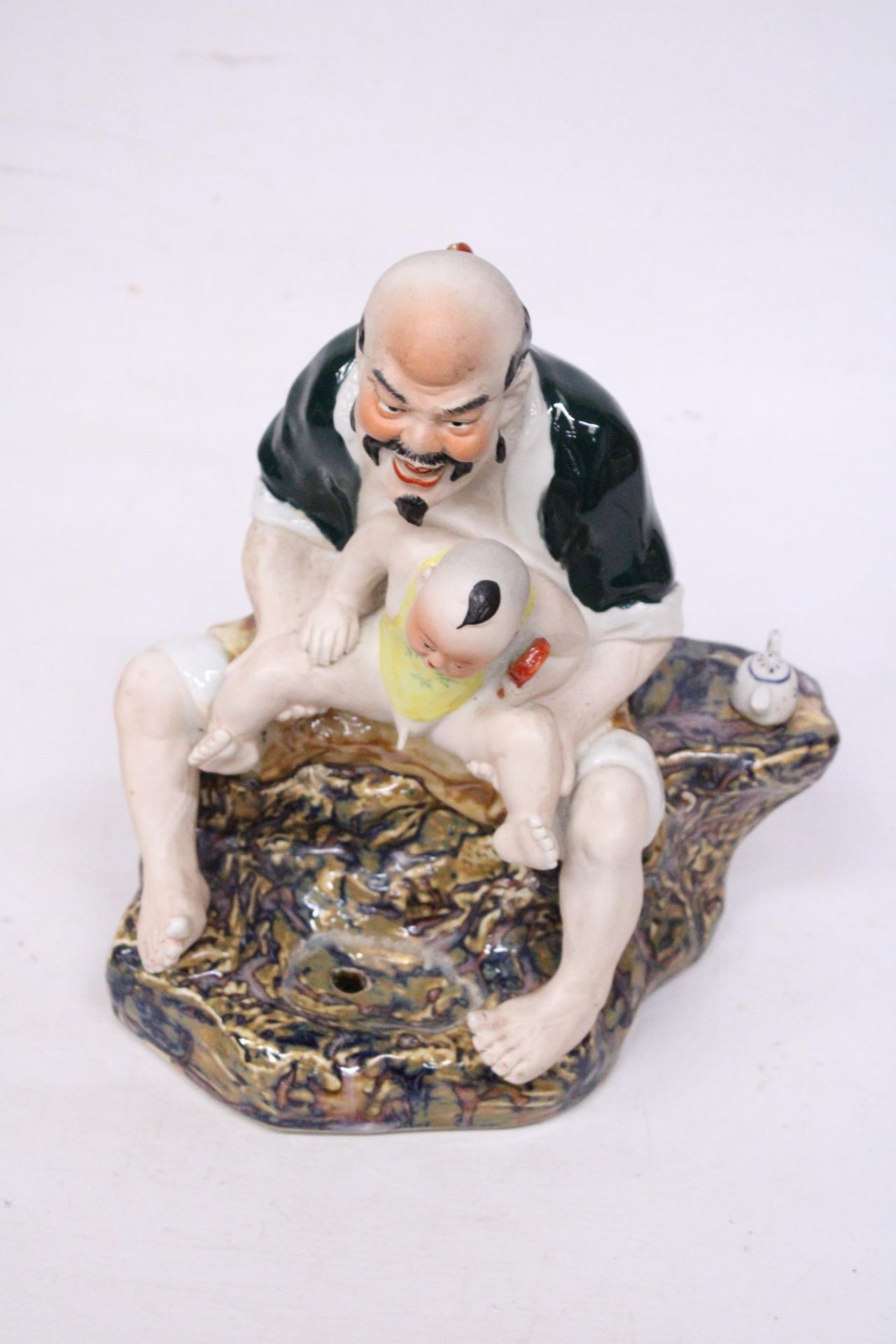 A CHINESE PORCELAIN MAN WITH BABY