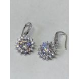 A PAIR OF WHITE METAL EARRINGS WITH 2 CARATS OF MOISSANITE IN A FLOWER DESIGN
