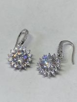 A PAIR OF WHITE METAL EARRINGS WITH 2 CARATS OF MOISSANITE IN A FLOWER DESIGN