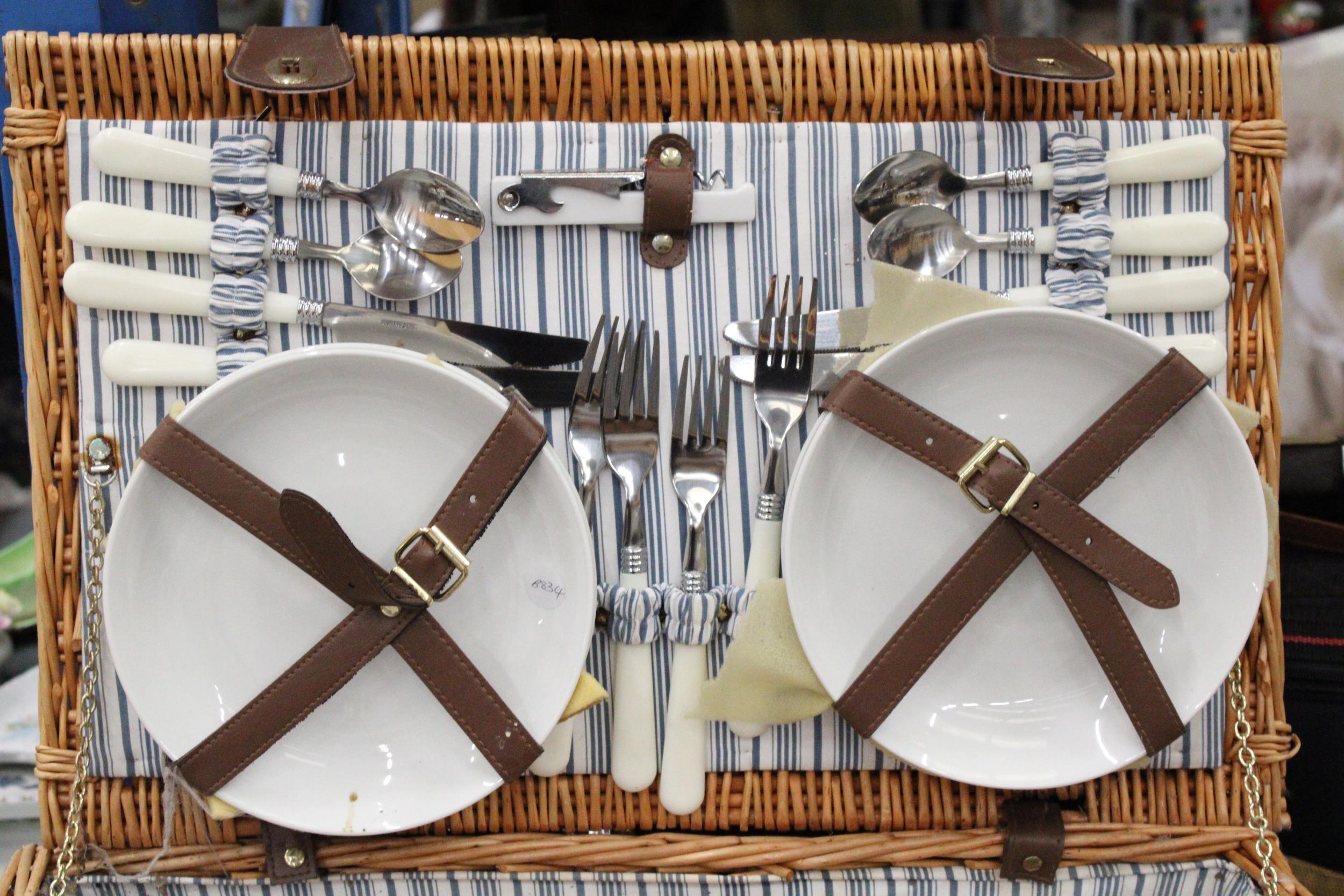 A LARGE WICKER PICNIC HAMPER CONTAINING CERAMIC CUPS AND PLATES, PLUS CUTLERY, A BOTTLE OPENER AND - Image 2 of 5