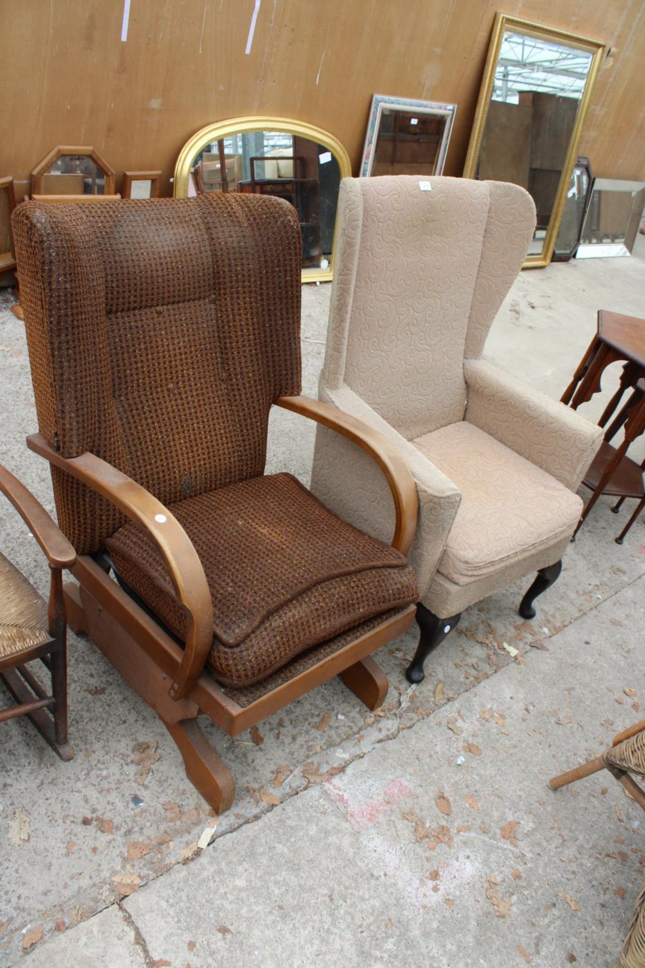 AN ART DECO STYLE ROCKING CHAIR AND WINGED FIRESIDE CHAIR ON CABRIOLE LEGS