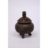 A METAL (POSSIBLY BRONZE) TRIPOD INCENSE HOLDER WITH FOO DOG FINIAL