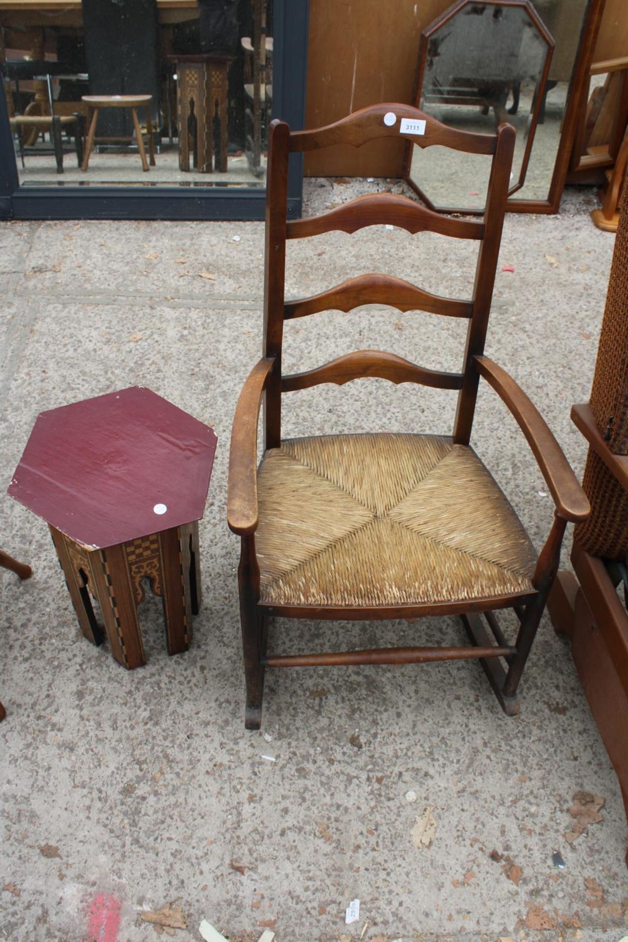 A BEECH FRAMED LADDER BACK ROCKING CHAIR AND A MOORISH STYLE HEXAGONAL TABLE