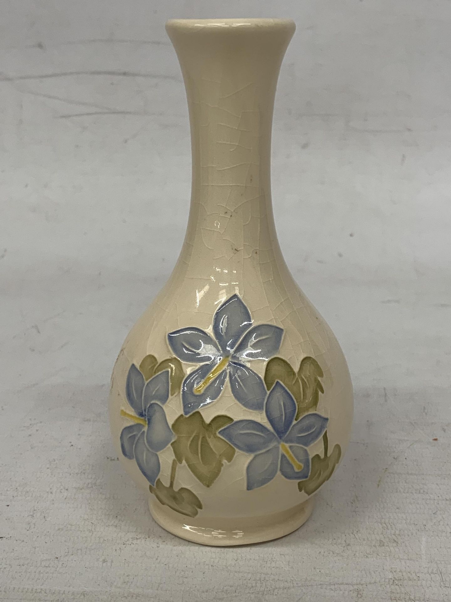 A MOORCROFT MOULDED RAISED DESIGN "CAMPANULA" VASE ON CREAM BACKGROUND