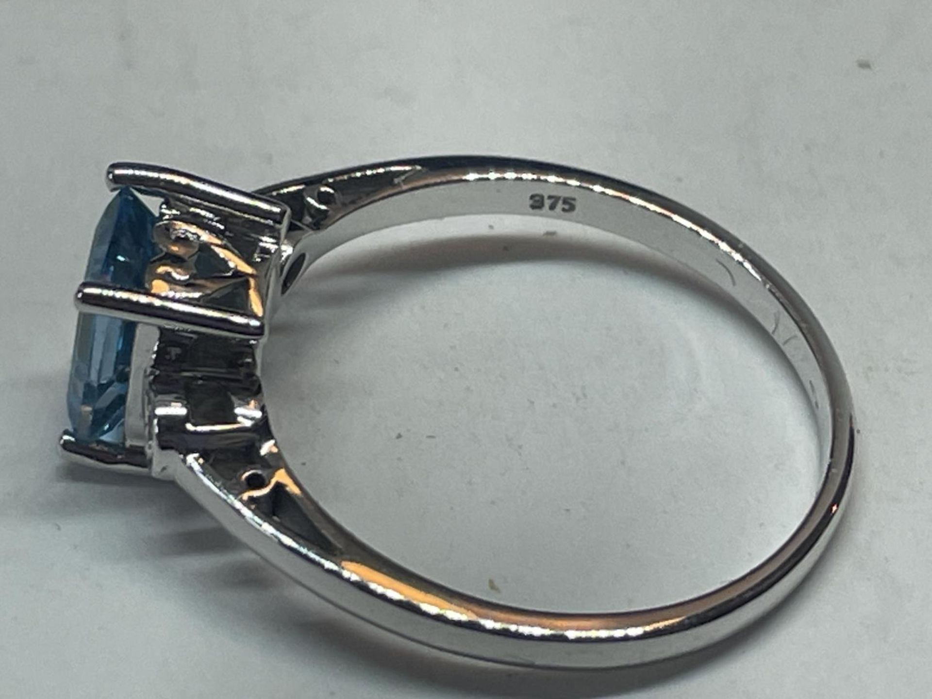 A 9 CARAT WHITE GOLD RING WITH A LARGE RECTANGULAR BLUE TOPAZ AND A DIAMOND EACH SIDE (EMERALD - Image 4 of 6