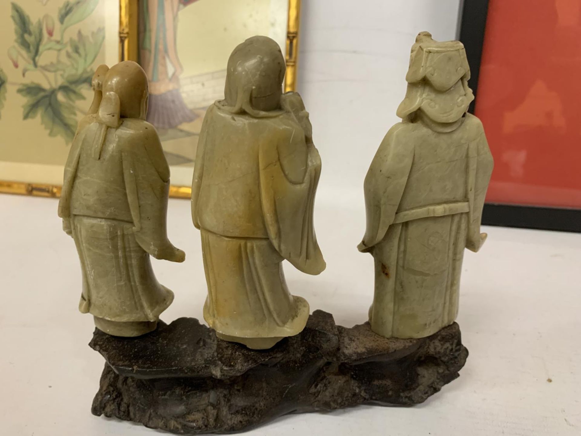 A FINE CHINESE CARVED SOAPSTONE FIGURE GROUP OF THREE IMMORTALS MOUNTED ON A CARVED STAND - Image 4 of 4