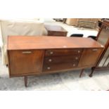 A RETRO TEAK SIDEBOARD ENCLOSING THREE DRAWERS AND TWO DROP-DOWN CUPBOARDS, 65" WIDE