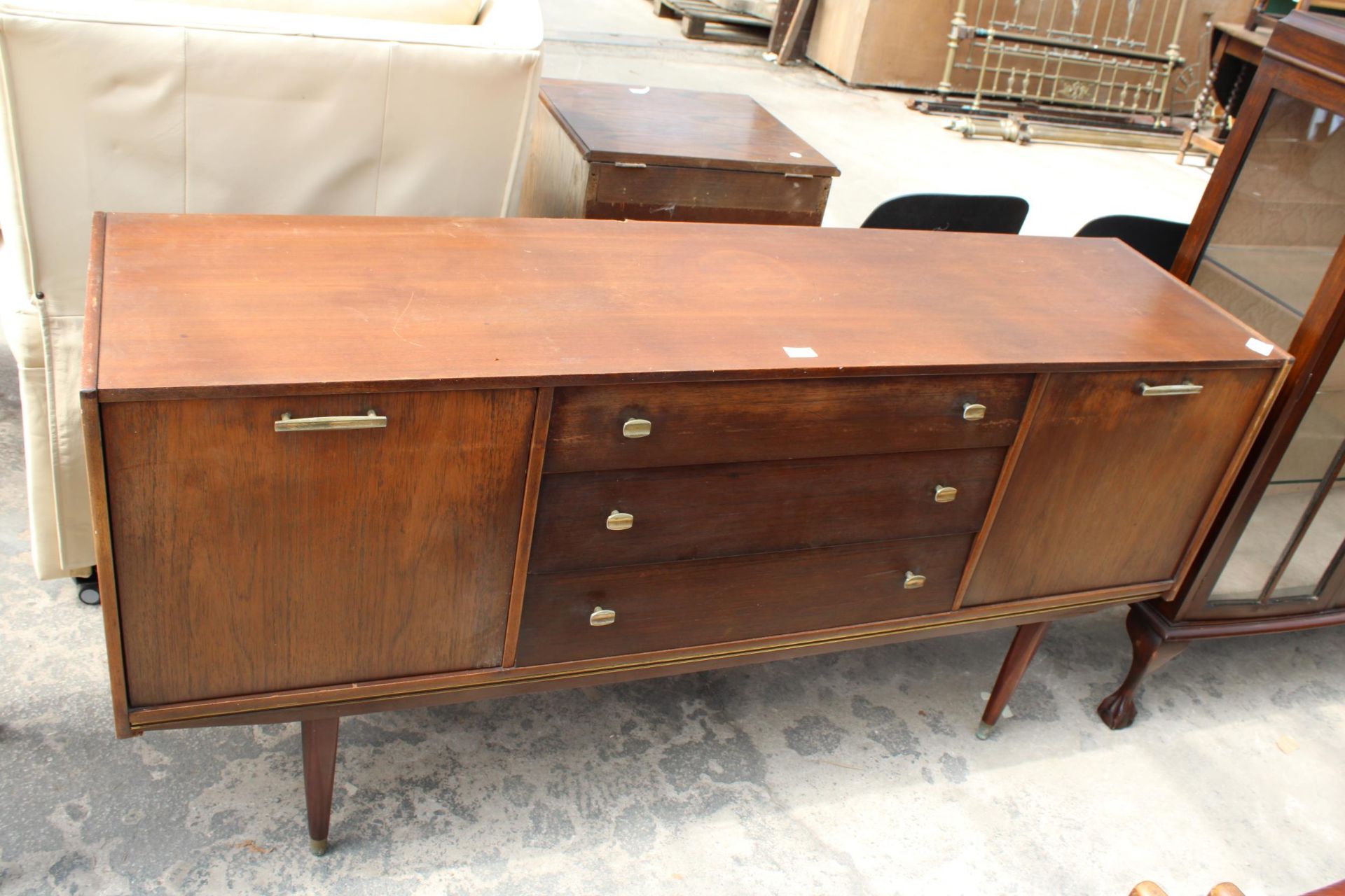 A RETRO TEAK SIDEBOARD ENCLOSING THREE DRAWERS AND TWO DROP-DOWN CUPBOARDS, 65" WIDE