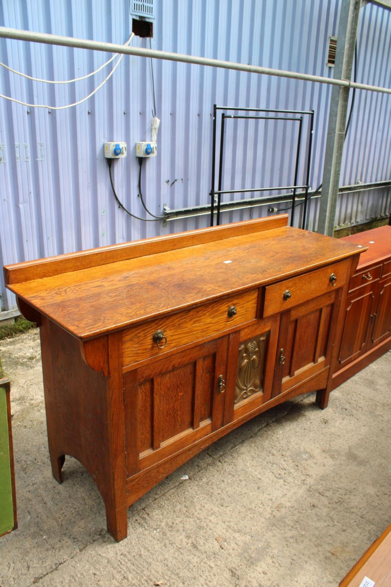 AN ART NOUVEAU OAK SIDEBOARD WITH CENTRAL EMBOSSED COPPER PANEL - 66" WIDE