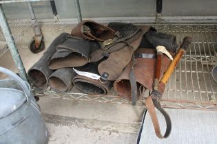 AN ASSORTMENT OF VINTAGE LEATHER RIDING CUFFS AND A RIDING CROP ETC