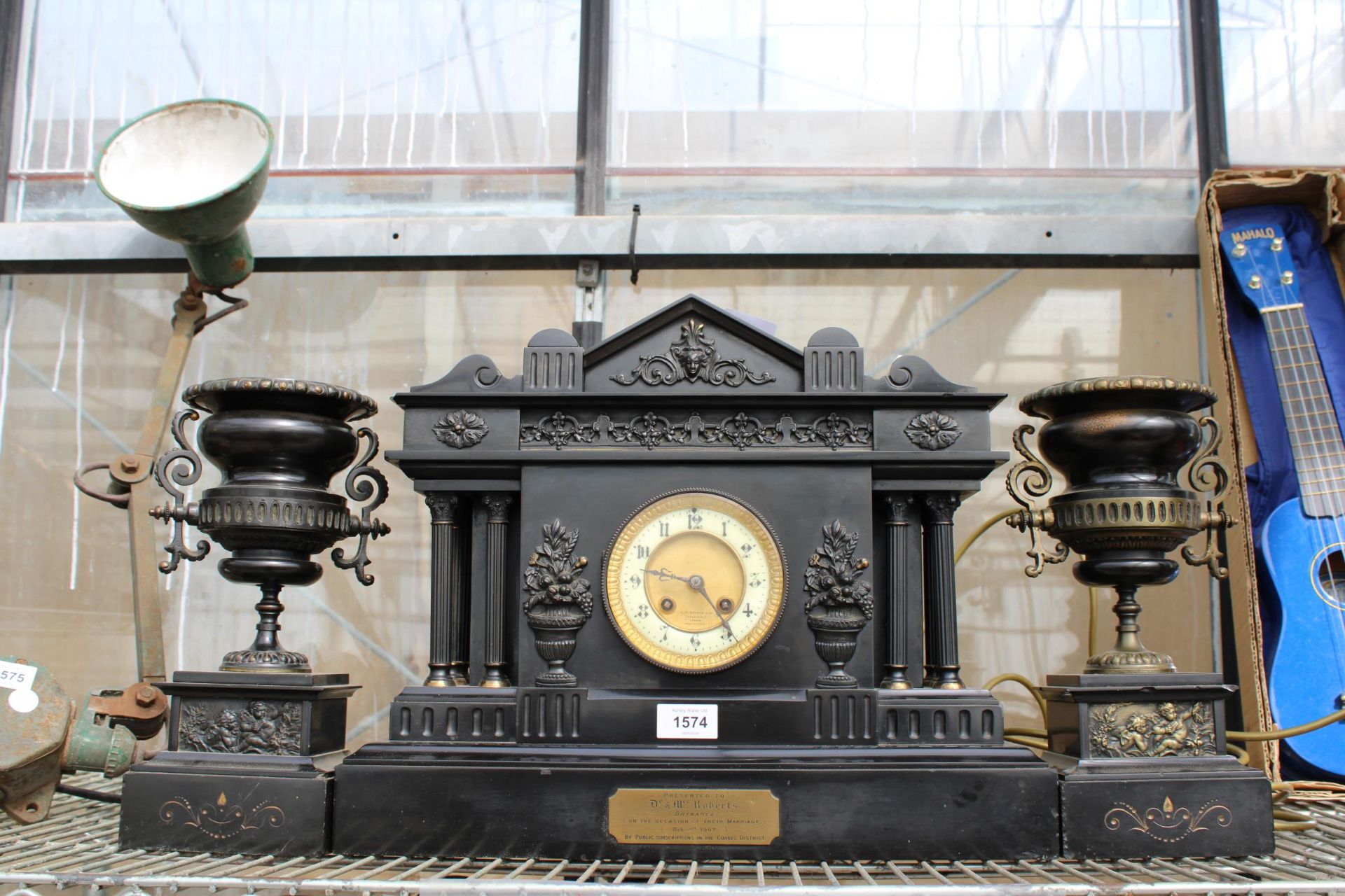 A HEAVY SLATE MANTLE CLOCK WITH A PAIR OF MATCHING CANDLE HOLDERS WITH PLAQUE INSCRIBED 'PRESENTED