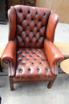 A MODERN BROWN BUTTON-BACK WINGED FIRESIDE CHAIR