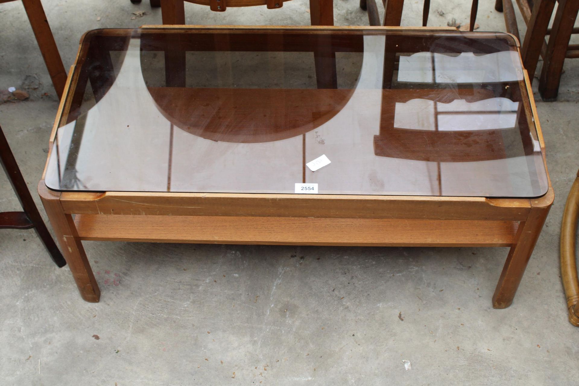 A RETRO TEAK TWO TIER COFFEE TABLE WITH SMOKED GLASS TOP, 34" X 17"
