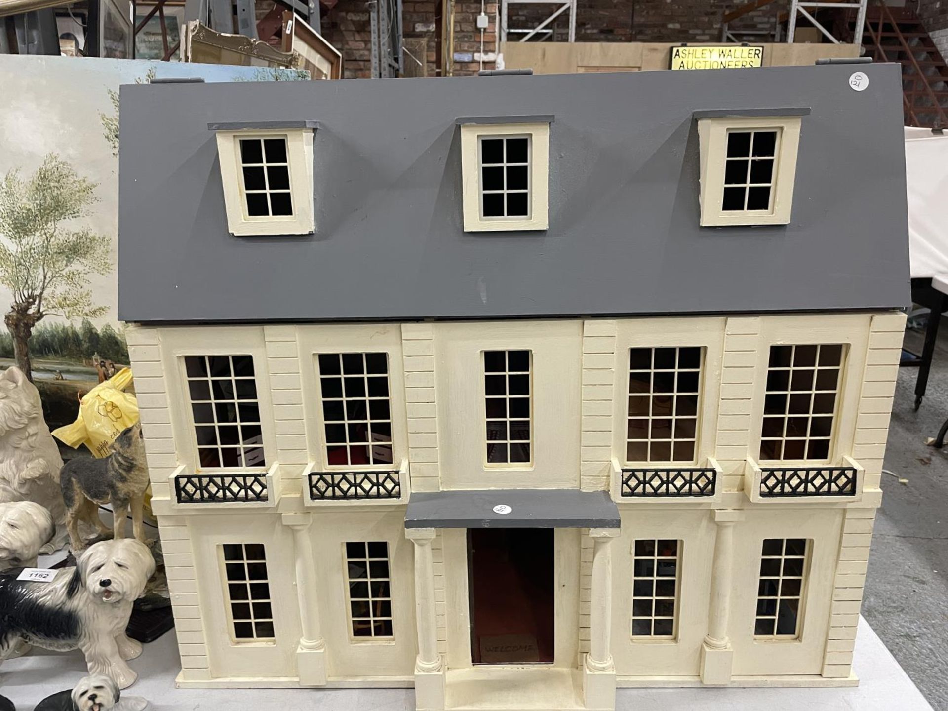 A VINTAGE THREE STOREY DOLLS HOUSE WITH FURNITURE AND LIGHTS